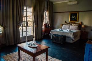 a bedroom with a bed and a coffee table at Farm stay at Saffron Cottage on Haldon Estate in Bloemfontein