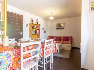 a living room with a table and chairs and a couch at Agréable T2 Cabine avec Piscine, Balcon et WiFi à Luz-Saint-Sauveur - FR-1-402-116 in Luz-Saint-Sauveur +3 photos