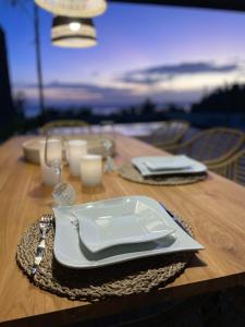 uma mesa com um prato branco sobre uma mesa de madeira em Villa Des Sens em Ruisseau Créole