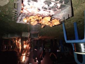 a grill with meat and chickens cooking on it at SAMZ ESTATE Stay 3BHK in Madikeri