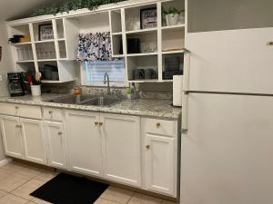 Una cocina con gabinetes blancos y un refrigerador blanco. en Downtown Heaven, en San Antonio