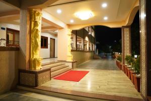 een hal van een gebouw met een rood tapijt op de vloer bij Raaj Resort in Panvel