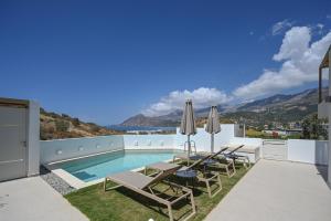 a villa with a swimming pool and patio furniture at Corallia villas near the beach in Plakias