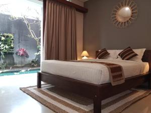 a bedroom with a bed and a mirror on the wall at Alia Home in Sanur