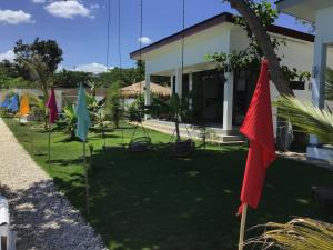 a yard with umbrellas in front of a house at BambooBeachVilla2 AC NEW OCEANFRONT POOL sunsetview garden kitchen SATELLITE STARLINK WI-FI in Dimiao