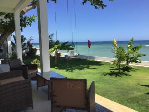 a porch with chairs and a view of the ocean at BambooBeachVilla2 AC NEW OCEANFRONT POOL sunsetview garden kitchen SATELLITE STARLINK WI-FI in Dimiao