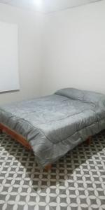 una cama en la parte superior de un suelo a cuadros en Departamento DYD JUJUY en San Rafael