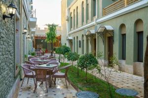 une rangée de tables et de chaises dans une ruelle dans l'établissement Hotel Malika Bukhara, à Boukhara