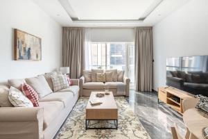 Frank Porter - Burj Al Nujoom في دبي: غرفة معيشة مع أريكة وطاولة
