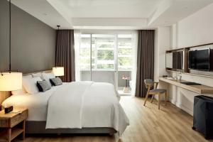 um quarto com uma cama grande e uma janela grande em Casa 17 Hotel Bangkok em Bangkok