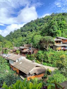 a group of houses on a hill with trees at Preanhuan Homestay in Mae On