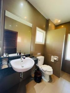 a bathroom with a sink and a toilet and a mirror at Bakantiang Resort in Ko Lanta