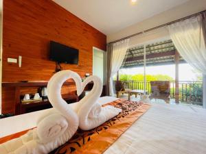 two swans shaped like swans sitting on a bed at Bakantiang Resort in Ko Lanta