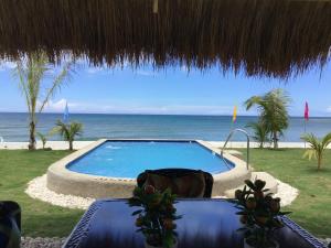 a swimming pool with a view of the ocean at BambooBeachVilla2 AC NEW OCEANFRONT POOL sunsetview garden kitchen SATELLITE STARLINK WI-FI in Dimiao +57 photos
