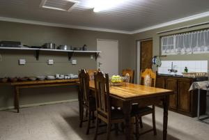 Farm stay at Lavender Cottage on Haldon Estate في بلومفونتين: مطبخ مع طاولة وكراسي خشبية