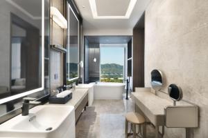 a bathroom with two sinks and a bath tub at The Barony Jinan East in Jinan +27 photos