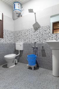 La salle de bains est pourvue de toilettes et d'un lavabo. dans l'établissement Aravindam House I Open Rooftop & Garden I Bonfire I By Vanasthali Kasauli, à Kasauli