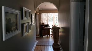 a hallway with an archway and a room with a window at Liza's Cottage Guesthouse in Pretoria