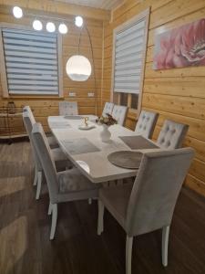 comedor con mesa blanca y sillas en Baložu rezidence, en Jūrmala