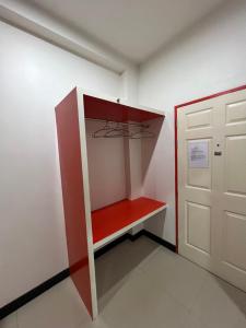 una habitación con un estante rojo junto a una puerta en โรงแรมช้างใหญ่ใจดี, en Yasothon