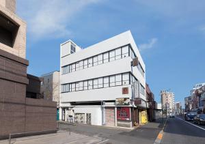東京にあるCOCOSHUKU中野の通路脇白い建物