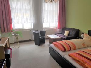 a living room with a couch and a chair at Pension Zur Altdeutschen in Zschopau