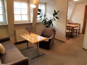 a living room with a table and chairs and a dining room at Pension Zur Altdeutschen in Zschopau