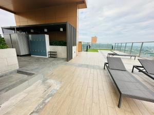 a balcony with benches and tables on a building at Plum central westgate@Bangyai in Ban Bang Krabu