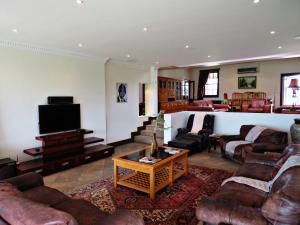 a large living room with couches and a tv at Trumpetters Drift Game Farm in Grahamstown