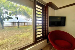 a red chair sitting in front of a window at Willo Stays Sea View Home Kannur Landsend in Kannur