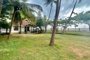 una pequeña casa con palmeras en un patio en Willo Stays Sea View Home Kannur Landsend en Kannur