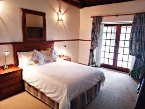 a bedroom with a large bed and a large window at Trumpetters Drift Game Farm in Grahamstown