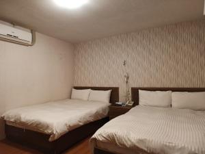 two beds in a small room with at Hotel Fouquet in Hualien City