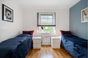 a bedroom with two beds and a window at Fagereng, Tromsø in Tromsø