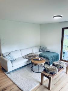 uma sala de estar com um sofá branco e uma mesa em Ferienhaus Granula em Linthal