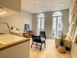een keuken en een woonkamer met een tafel en stoelen bij Nieuw appartement in Leuven centrum! in Leuven