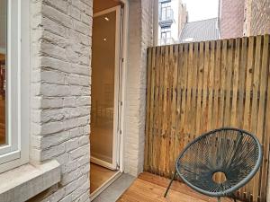 einen Stuhl auf einer Veranda neben einem Holzzaun in der Unterkunft Nieuw appartement in Leuven centrum! in Löwen