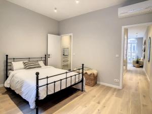 een slaapkamer met een groot bed en een houten vloer bij Nieuw appartement in Leuven centrum! in Leuven