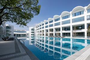 an exterior view of a building with a swimming pool at White Swan Hotel Taizhou in Taizhou
