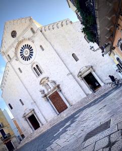 a large white building with a clock tower at Dimora Pietra Antica in Bari