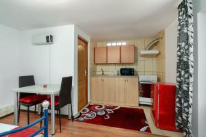 una pequeña cocina con mesa y nevera roja en Stone Gate Apartment #3, en Bucarest