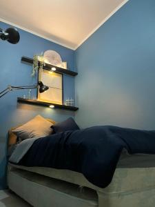 een slaapkamer met een bed met een blauwe muur bij Minyo Guest House in Jakarta
