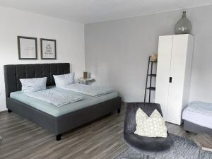 1 dormitorio con 2 camas y 1 silla en Weinquartier Naumburg, en Naumburg