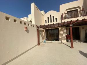 a large white building with a patio in front of it at Cove private one bedroom lagoon villa in Ras al Khaimah