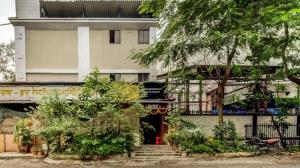 a building with stairs and trees in front of it at Hotel Raj Inn in Navi Mumbai