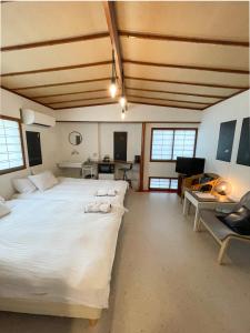 a large bedroom with a large bed and a desk at Kikusui Ryokan in Tamano