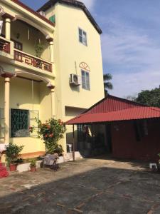 a large yellow building with a red roof at Nhà Nghỉ Bình Dân Xanh in Bắc Quang