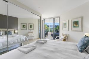 a bedroom with a bed and a glass wall at Cotton Beach Resort - Tweed Coast Holidays ® in Kingscliff