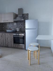 Il comprend une cuisine équipée d'un réfrigérateur blanc, d'une table et de chaises. dans l'établissement Aqua Apartments, à Loutra Elenis