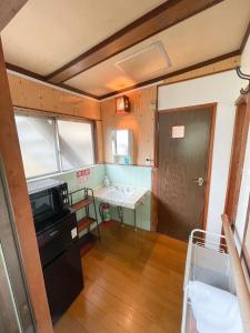 a room with a bed and a kitchen with a door at Kikusui Ryokan in Tamano +172 photos